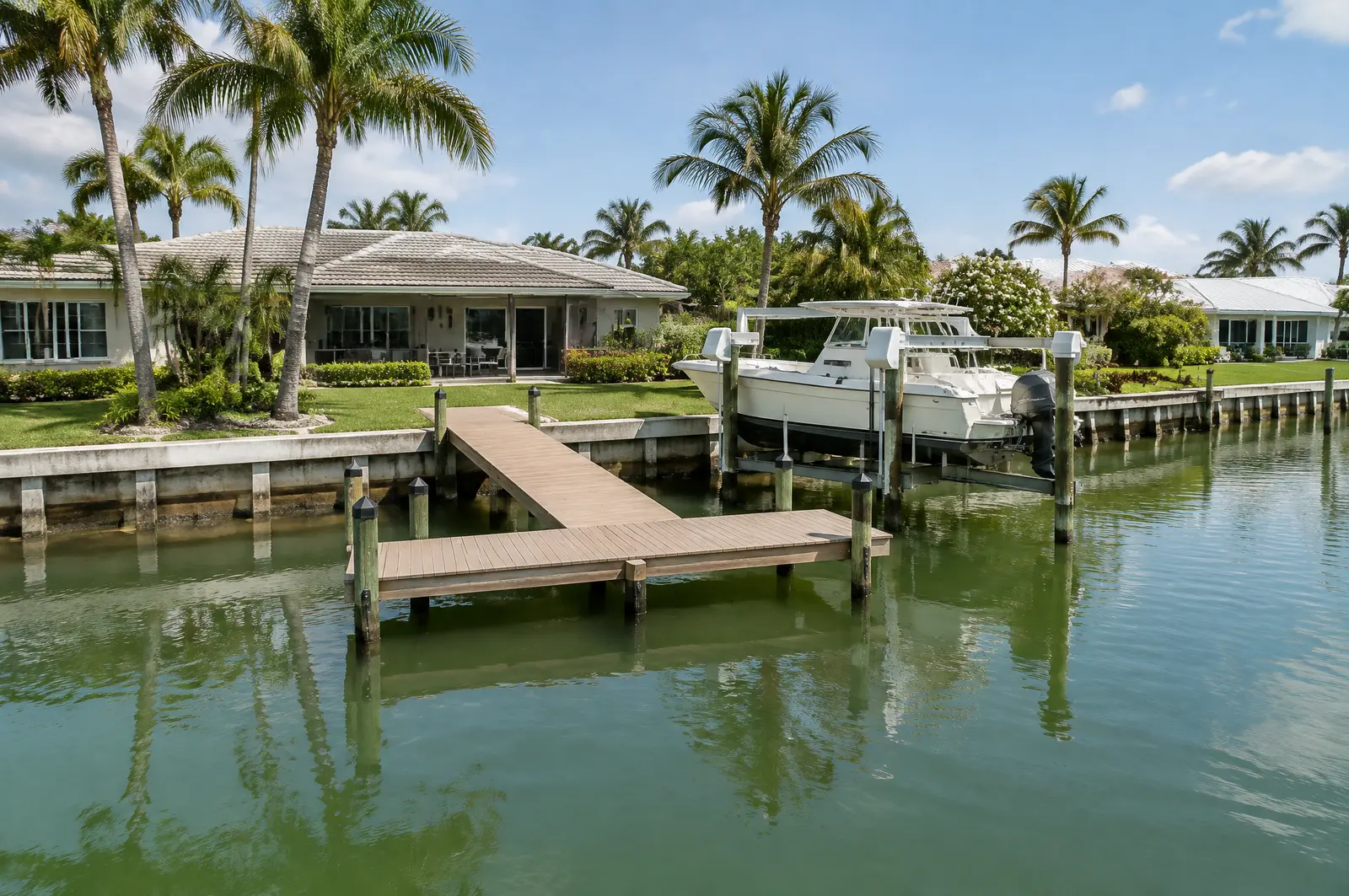 T-shaped dock and a boat lift parallel to the bulkhead on a narrow residential canal
