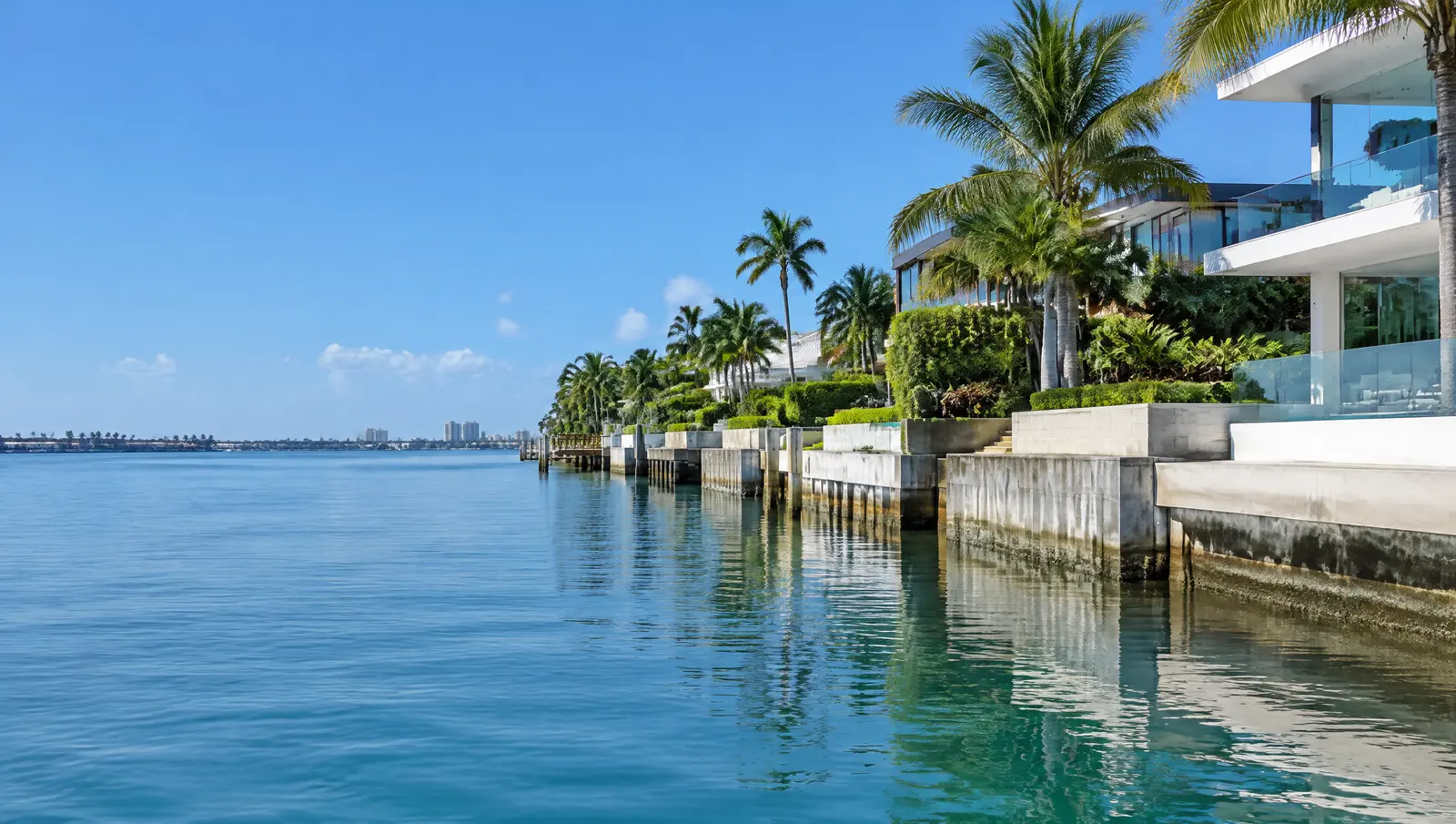 Row of bay-side seawalls raised to different heights, with visible steps where caps meet