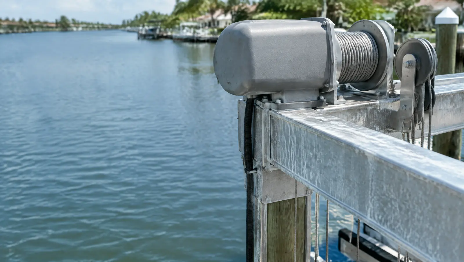 Boat lift top beam with an unmarked electric motor, cable drum, stainless cables and pulleys